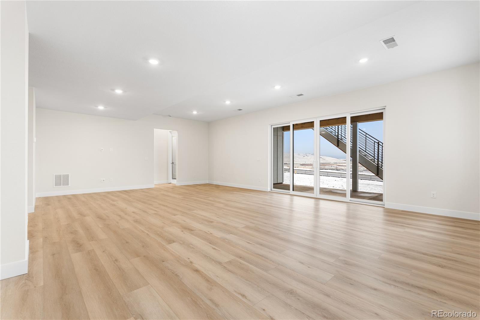 11303 Tenor Trail Lone Tree, CO 80134 - Photo 18 of 49 a view of an empty room with wooden floor and windows