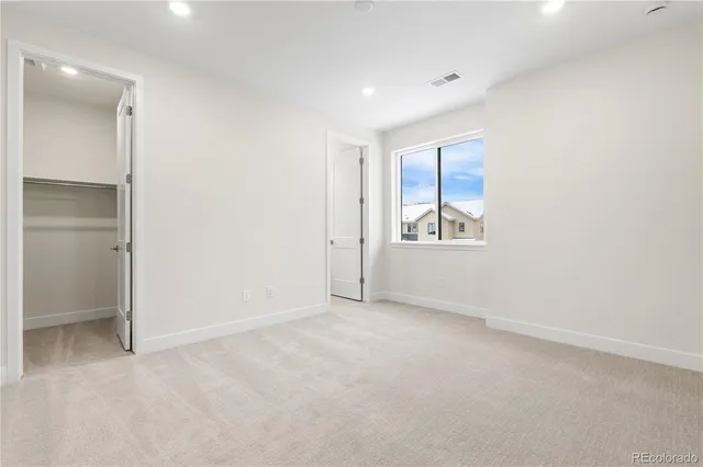 an empty room with windows and closet