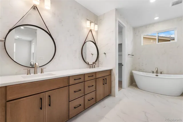 a bathroom with a double vanity sink mirror and bathtub