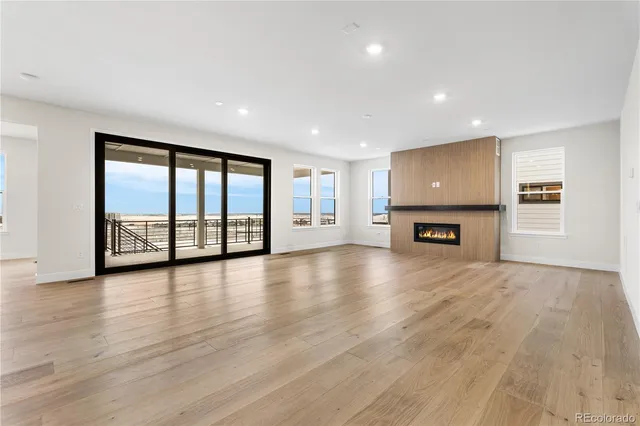a view of an empty room with a window and fireplace