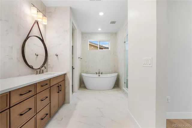 a bathroom with a double vanity sink mirror and bathtub