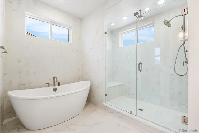 a white bath tub sitting next to a shower