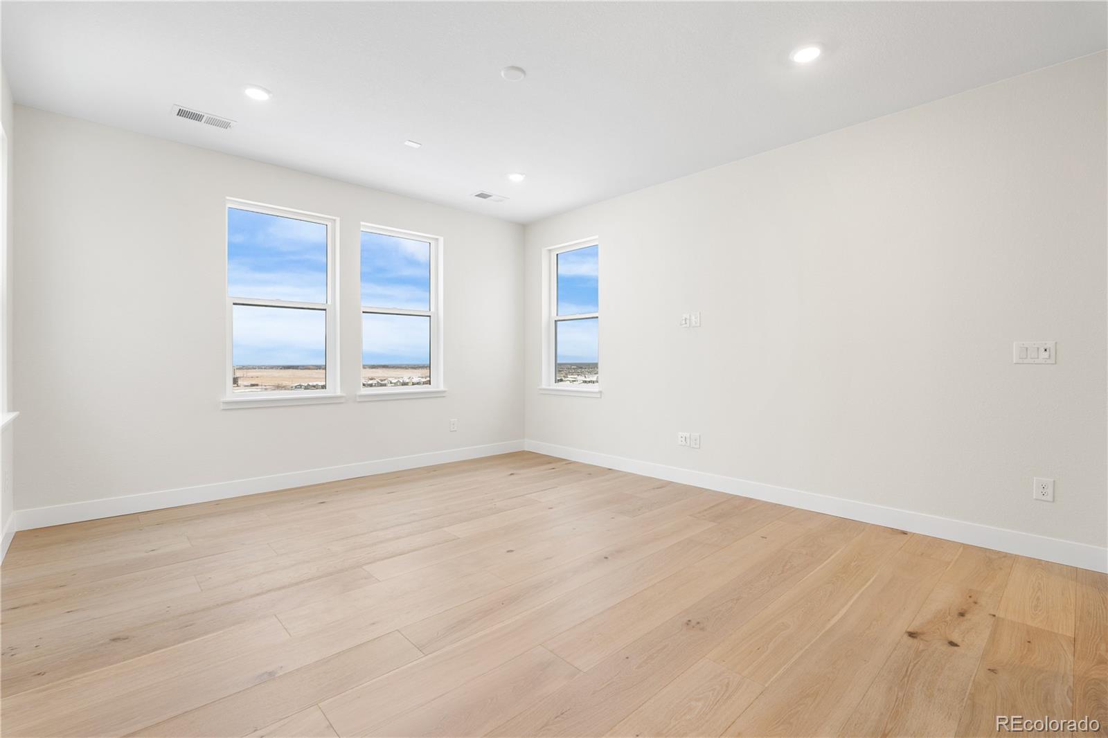 11303 Tenor Trail Lone Tree, CO 80134 - Photo 43 of 49 an empty room with wooden floor and windows