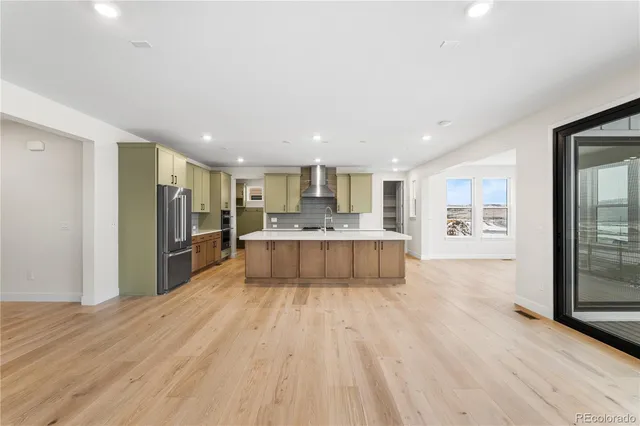 a large kitchen with stainless steel appliances granite countertop a large counter top a stove and a refrigerator