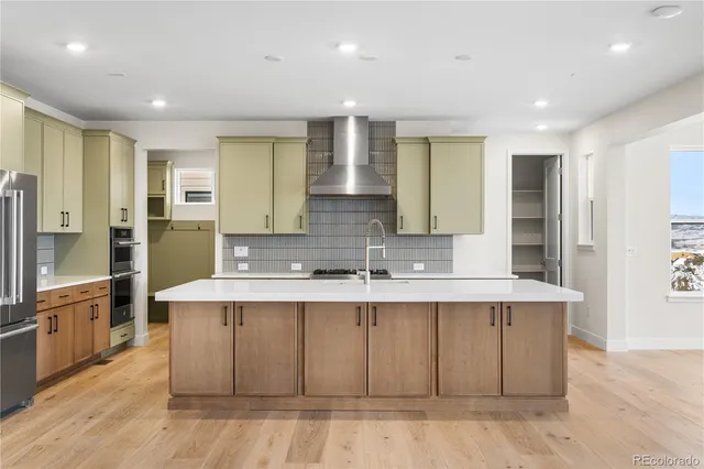 a large kitchen with kitchen island a sink stainless steel appliances and cabinets