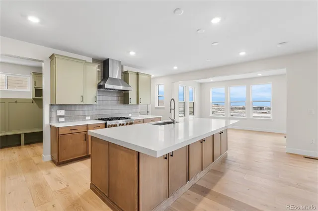 a large kitchen with stainless steel appliances a sink stove and cabinets