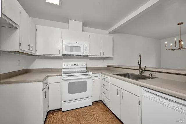 a kitchen with white cabinets stainless steel appliances and sink