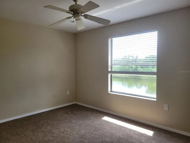 a view of a big room with closet and a chandelier fan