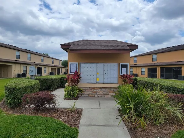 a front view of a house with a yard and potted plants