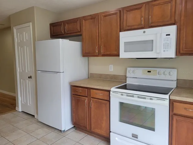 a kitchen with a stove top oven and refrigerator