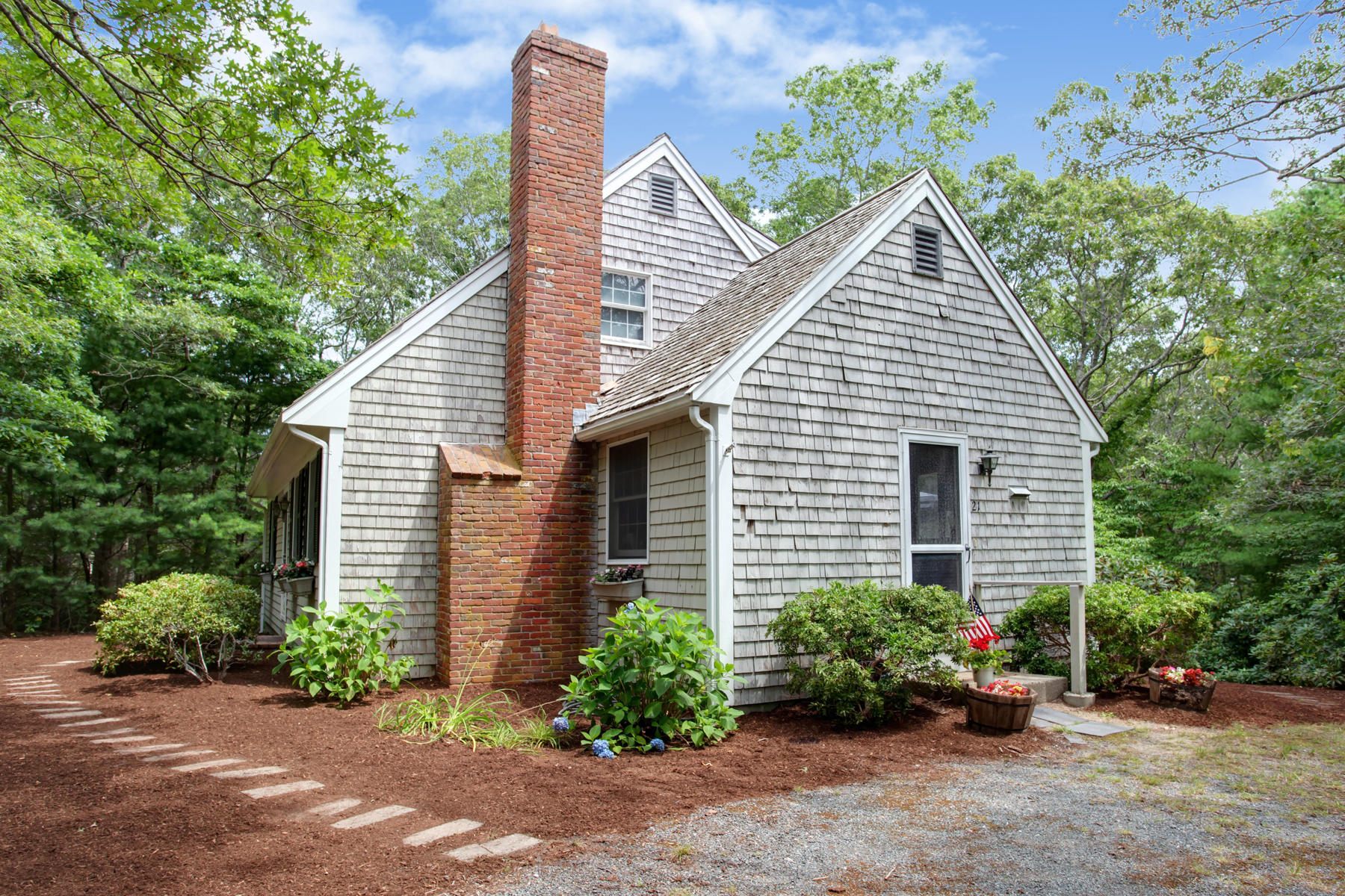 a view of a house with a yard and potted plants