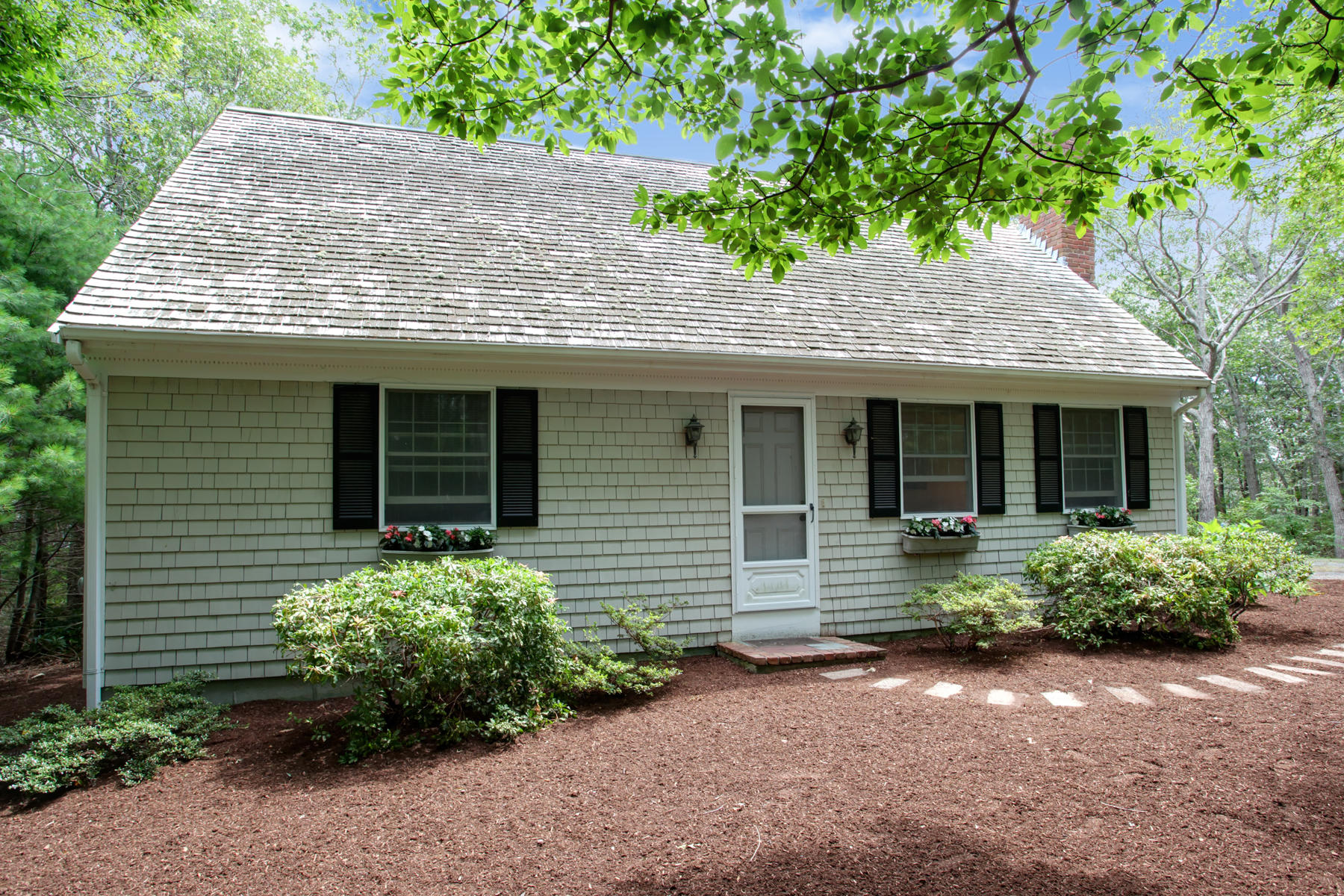 21 Oak Ridge Road East Sandwich, MA 02537 - Photo 5 of 31 a front view of a house with a garden and plants