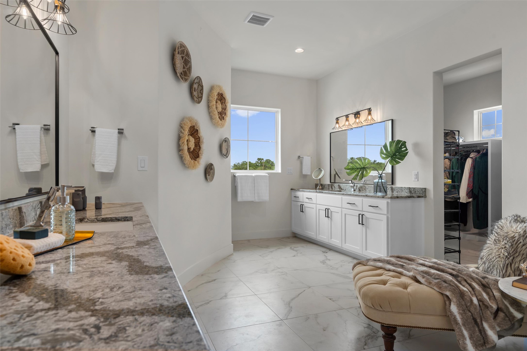 1805 Performer Road Spicewood, TX 78669 - Photo 13 of 40 Spacious primary bathroom featuring dual vanities an oversized walk in shower, and a large walk-in closet with separate his and hers areas.