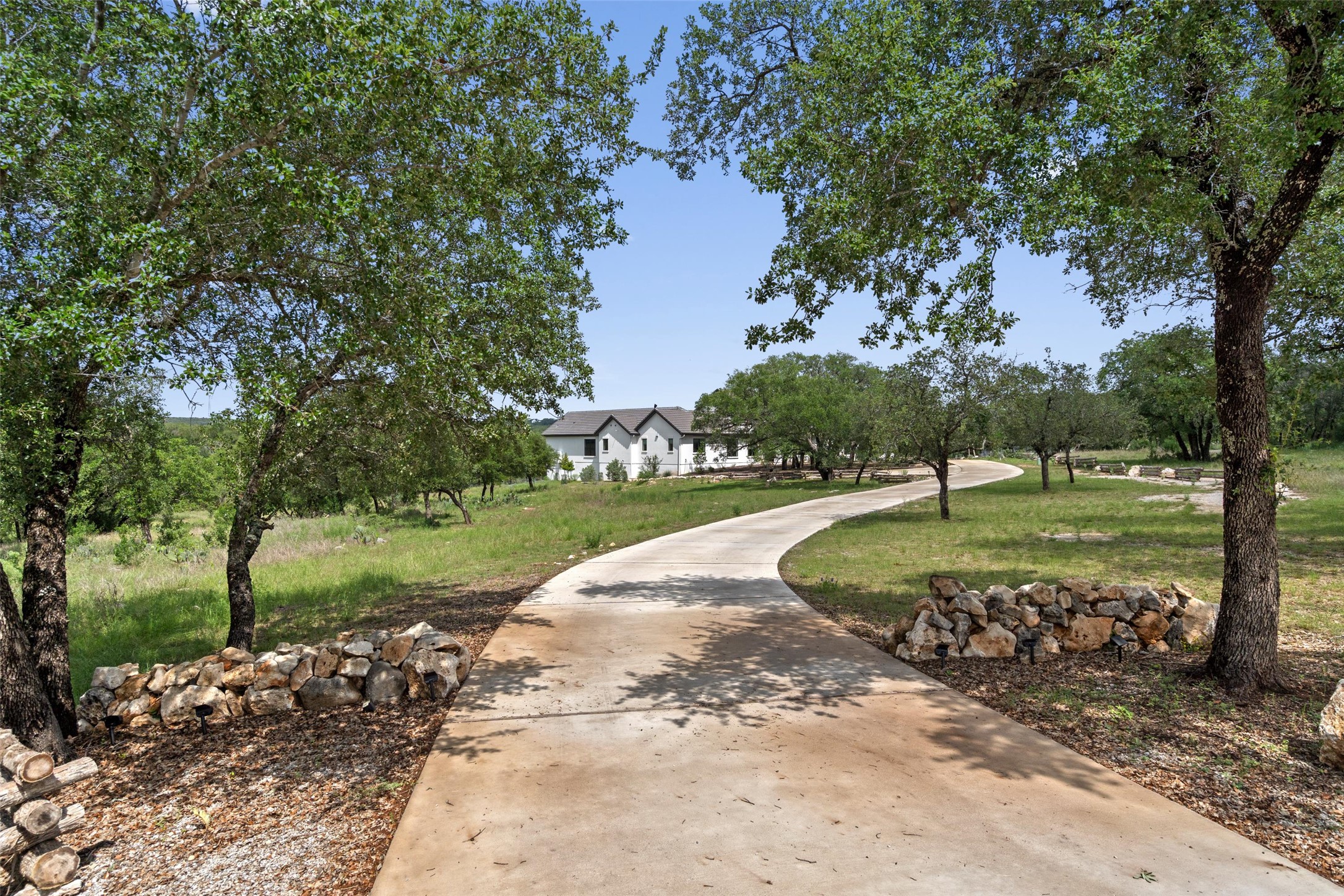 1805 Performer Road Spicewood, TX 78669 - Photo 2 of 40 Curved concrete driveway framed by mature trees and natural stone borders, lead you to this one of a kind home