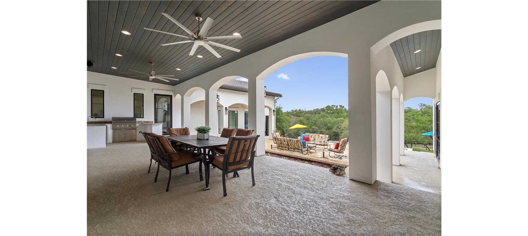 1805 Performer Road Spicewood, TX 78669 - Photo 21 of 40 Spacious covered patio with an elegant dark wood-finish plank ceiling, recessed lighting, and dual ceiling fans