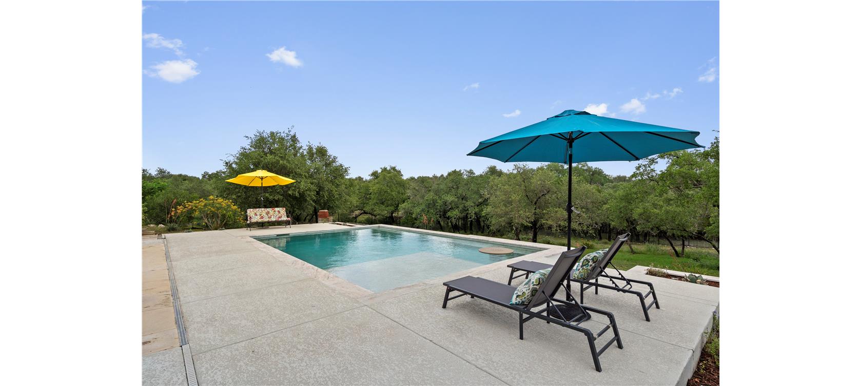 1805 Performer Road Spicewood, TX 78669 - Photo 29 of 40 Resort style pool with built-in umbrella holes, and expansive decking for lounging.