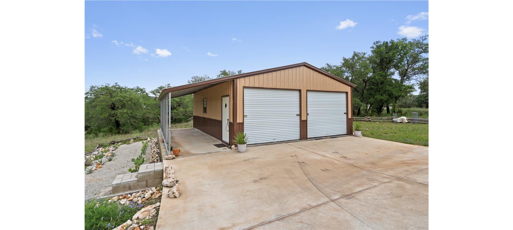 1805 Performer Road Spicewood, TX 78669 - Photo 36 of 40 metal exterior garage with a covered carport perfect for boat or RV