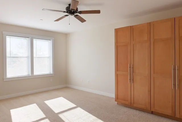 an empty room with windows and fan