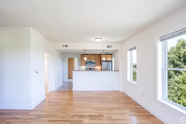 a view of a room with wooden floor and a window