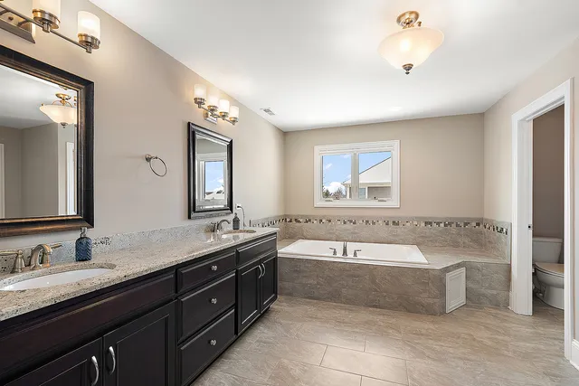 a bedroom with a bed dresser and a chandelier