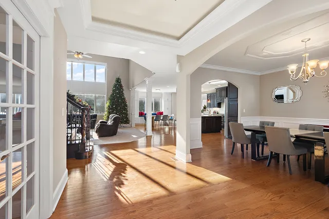 a view of a dining room with furniture a chandelier and wooden floor