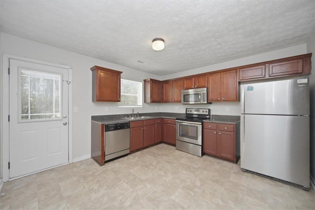100 Wexford Way Covington, GA 30014 - Photo 15 of 37 a kitchen with granite countertop stainless steel appliances and refrigerator