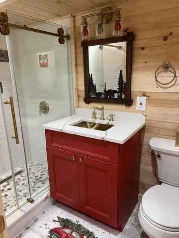 a bathroom with a sink a toilet and shower