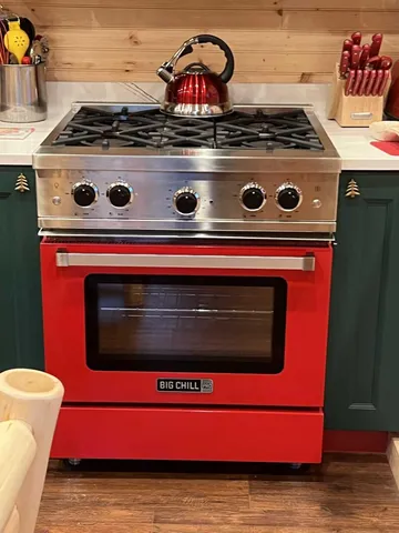 a stove top oven sitting inside of a kitchen