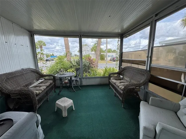 a living room with furniture and a floor to ceiling window