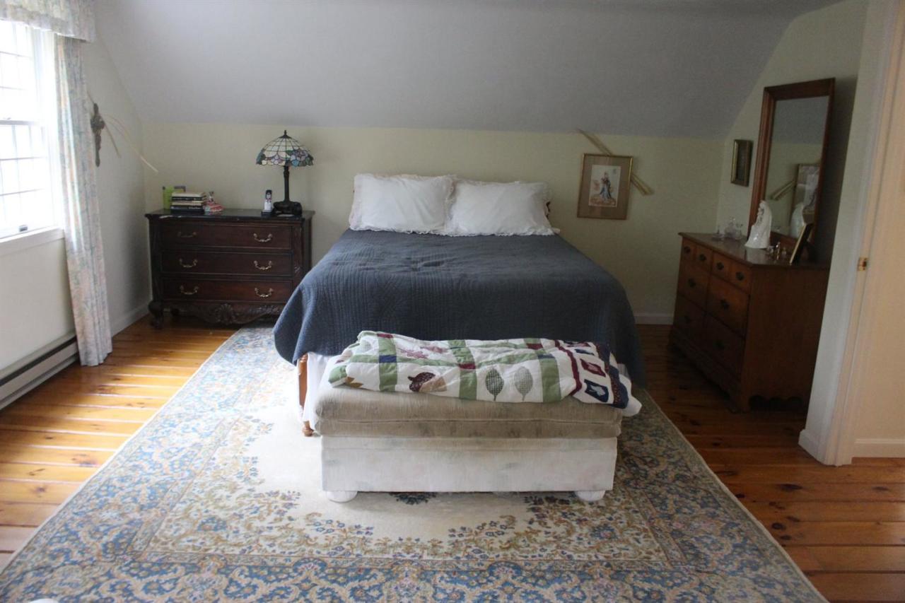 40 Lighthouse Lane Eastham, MA 02642 - Photo 18 of 33 a large bed sitting in a bedroom next to a window with dresser