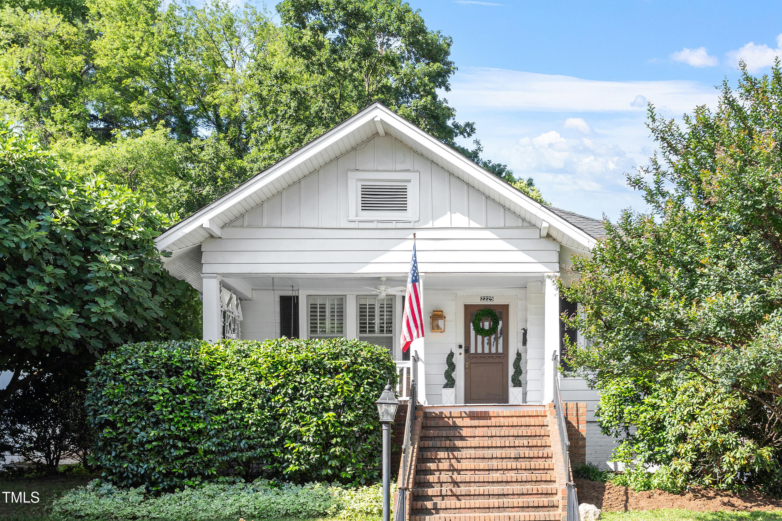 2225 Creston Road Raleigh, NC 27608 - Photo 1 of 27 a view of a white house with large windows and a small yard