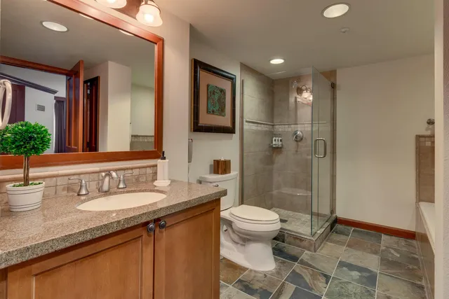 a bathroom with a tub shower vanity and a sink