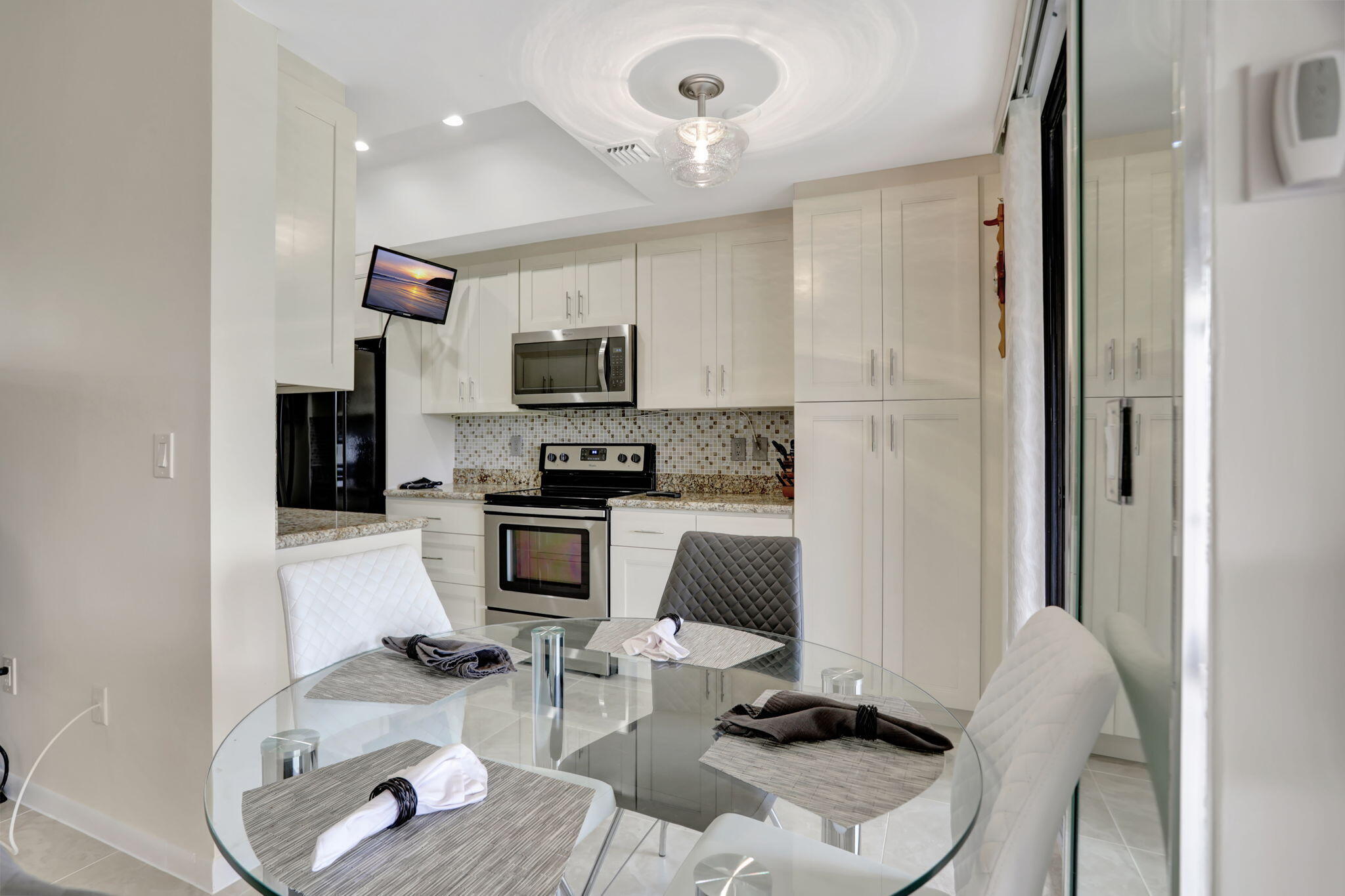 7460 La Paz Boulevard, Unit 108 Boca Raton, FL 33433 - Photo 13 of 40 a kitchen with stainless steel appliances kitchen island granite countertop a sink and cabinets