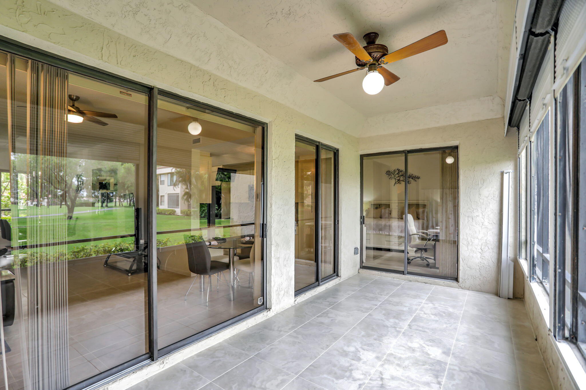 7460 La Paz Boulevard, Unit 108 Boca Raton, FL 33433 - Photo 17 of 40 a view of a porch with a floor to ceiling window and a kitchen