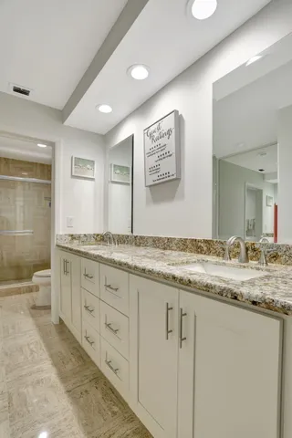 a bathroom with granite countertop double vanity and a granite