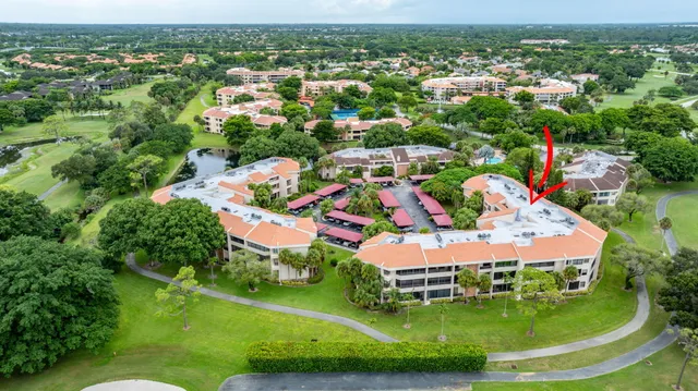 an aerial view of residential houses with outdoor space and trees