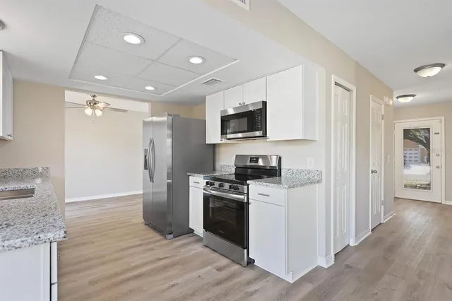 a kitchen with granite countertop a stove top oven a sink and a refrigerator