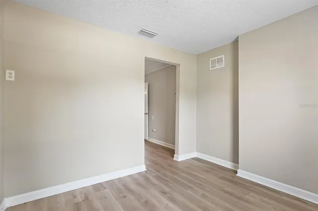 a view of an empty room with wooden floor