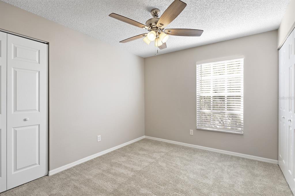 2107 Shady Point Lane Brandon, FL 33510 - Photo 25 of 38 an empty room with windows and fan