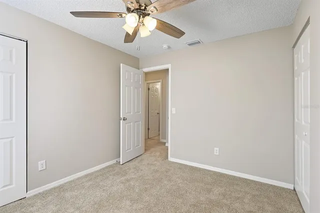 an empty room with a fan and a fan