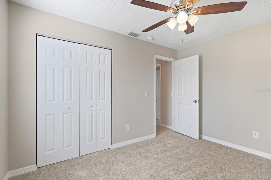 2107 Shady Point Lane Brandon, FL 33510 - Photo 29 of 38 an empty room with windows and fan