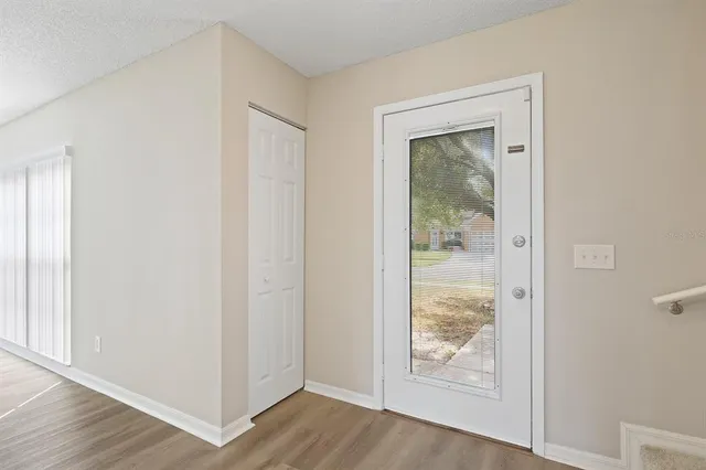 an empty room with wooden floor front door