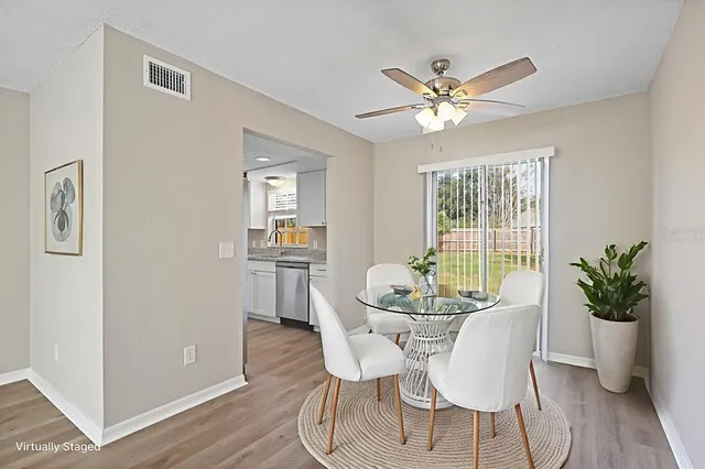 a dining room with furniture potted plants and wooden floor
