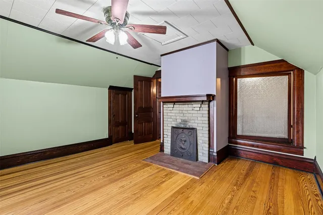 a view of an empty room with a fireplace and a window