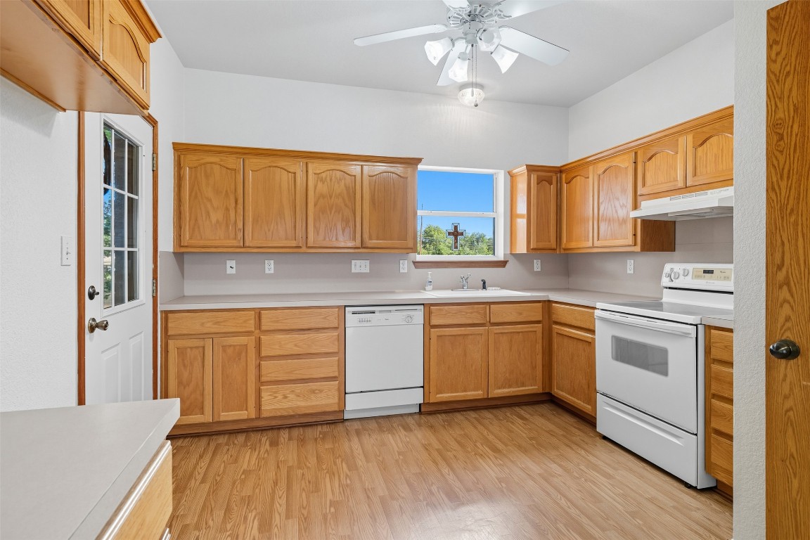 105 Davis Drive Thorndale, TX 76577 - Photo 23 of 40 a kitchen with stainless steel appliances granite countertop a sink cabinets and wooden floor