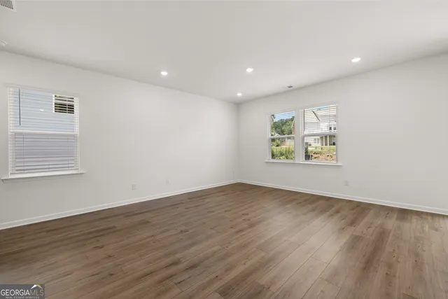 an empty room with wooden floor and window