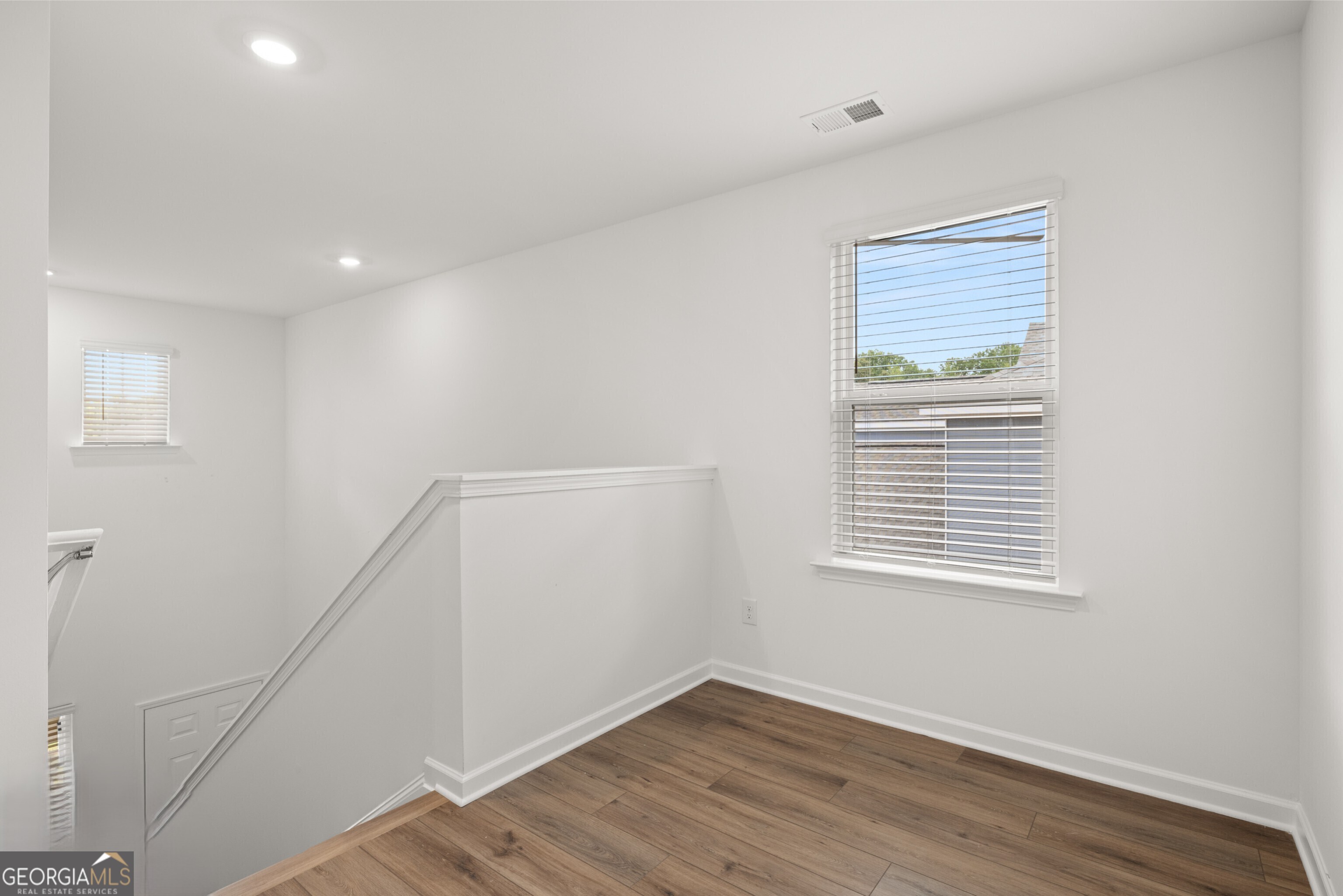 2464 Lennox Road Southeast Conyers, GA 30094 - Photo 18 of 27 a view of an empty room with wooden floor and a window
