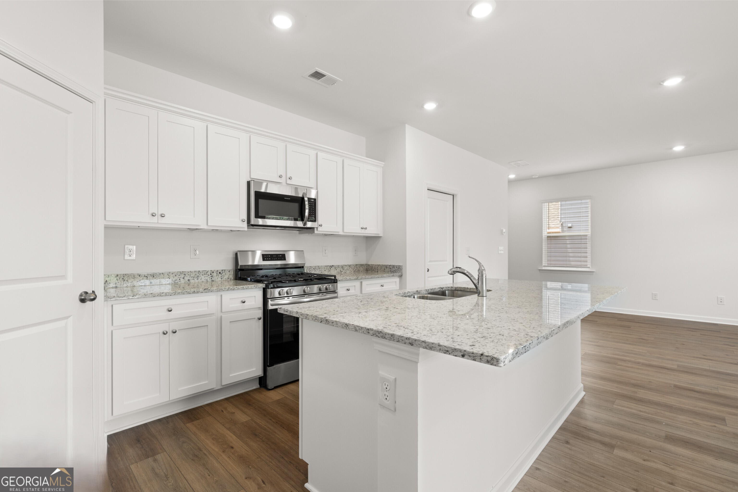 2464 Lennox Road Southeast Conyers, GA 30094 - Photo 7 of 27 a kitchen with granite countertop white cabinets and stainless steel appliances