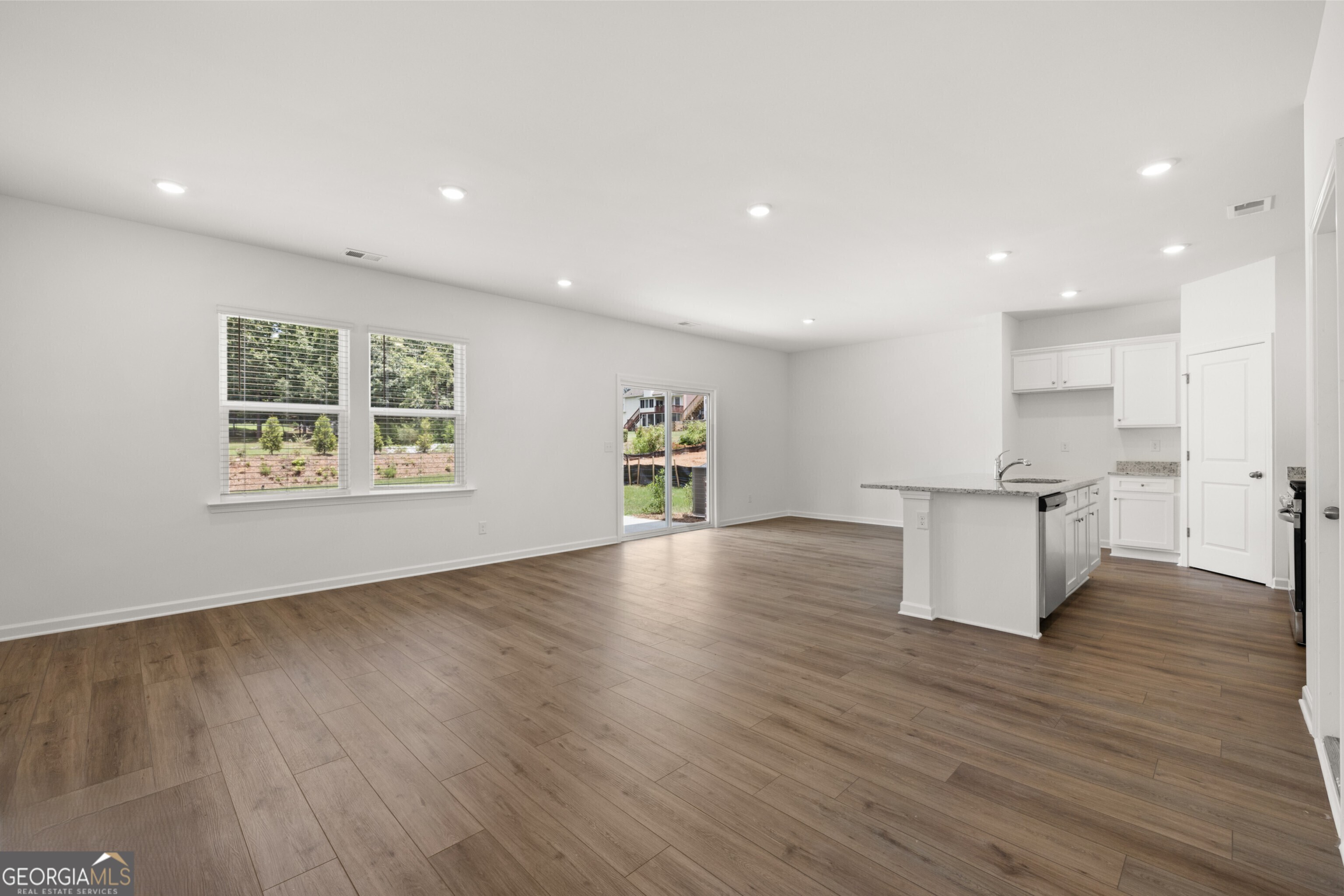 2464 Lennox Road Southeast Conyers, GA 30094 - Photo 9 of 27 a view of an empty room with wooden floor and a window