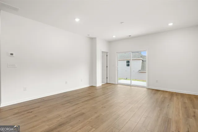 a view of an empty room with wooden floor